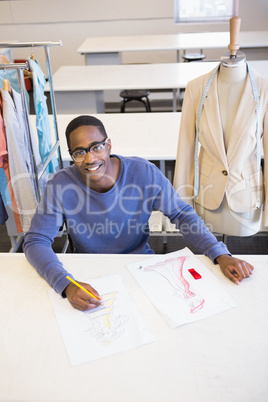 Smiling student drawing picture with colored pencil