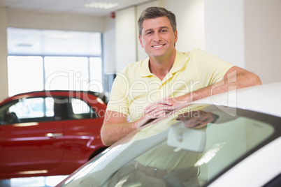 Smiling customer leaning on car