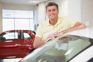 Smiling customer leaning on car