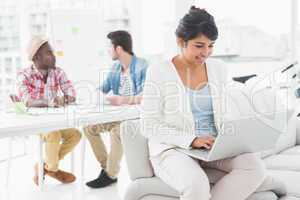 Smiling businesswoman using laptop on couch