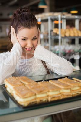 Pretty brunette looking at pastrys