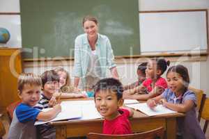 Teacher and pupils working at desk together