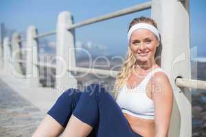 Fit blonde sitting on the pier