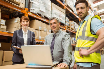 Smiling warehouse team looking at camera