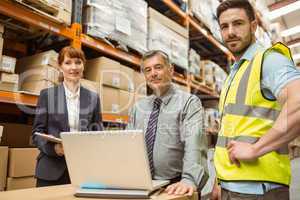 Smiling warehouse team looking at camera