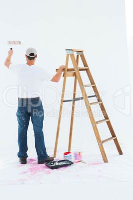 Man painting by step ladder on white background