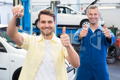Customer and mechanic smiling at camera