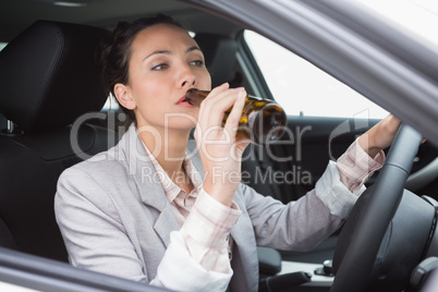 Woman drinking beer while driving