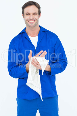 Confident mechanic wiping hand with napkin