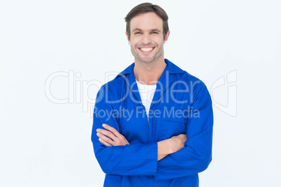 Happy mechanic with arms crossed over white background