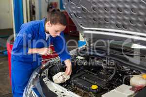 Mechanic checking the oil of car