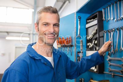 Mechanic taking a tool from wall