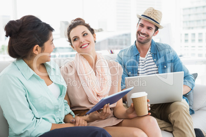 Smiling colleagues chatting together on couch