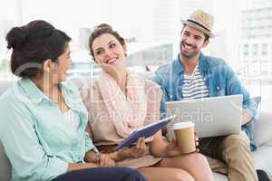 Smiling colleagues chatting together on couch