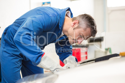 Mechanic examining under hood of car