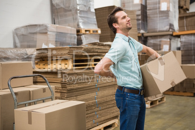 Worker carrying box in warehouse