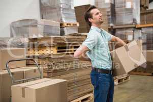 Worker carrying box in warehouse