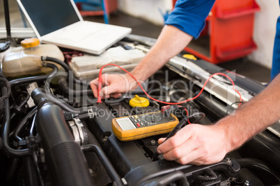 Mechanic using diagnostic tool on engine