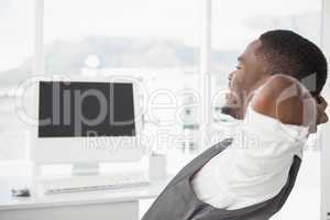 Relaxed businessman with hands behind head