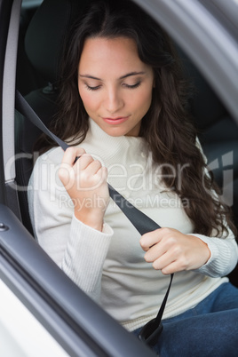 Woman putting on her seat belt