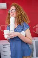 Student holding pile of coffee cup