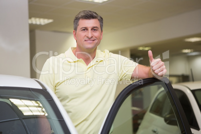 Smiling couple standing while giving thumbs up