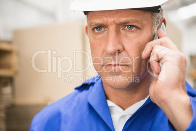 Worker using mobile phone in warehouse