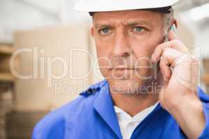 Worker using mobile phone in warehouse