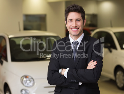 Smiling businessman standing with arms crossed