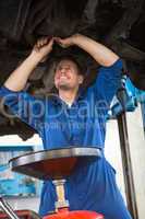 Mechanic examining under the car