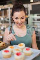 Pretty brunette picking out a cupcake