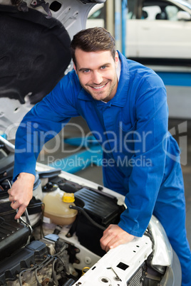 Mechanic examining under hood of car