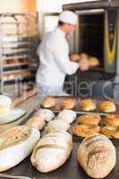 Happy baker taking out fresh loaves