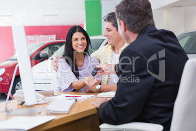 Salesman giving car keys to a couple