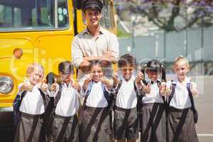 Cute pupils with their school bus driver