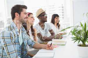 Smiling coworkers sitting and taking notes