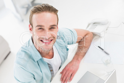 Happy businessman sitting using laptop
