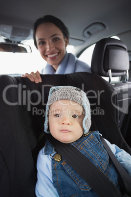 Mother checking her baby in the car seat