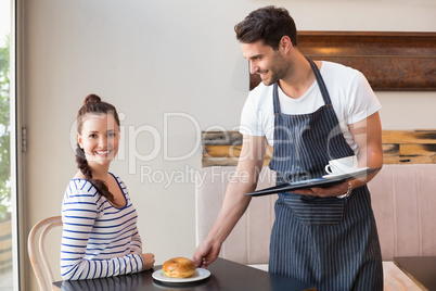 Pretty brunette being served a bagel