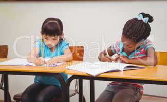 Pupils writing in notepad at their desk