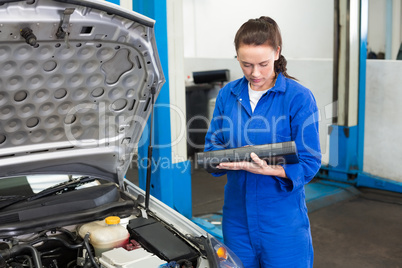 Mechanic examining under hood of car