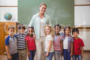 Cute pupils smiling at camera in classroom