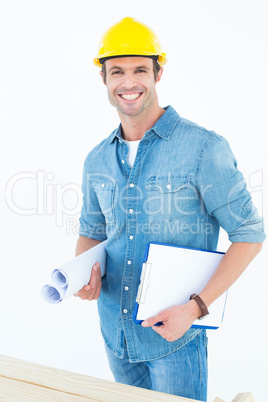 Happy carpenter holding rolled blueprint and clipboard