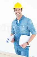 Happy carpenter holding rolled blueprint and clipboard