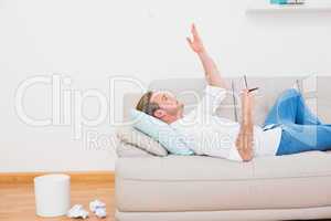 Man thinking on couch with writer block