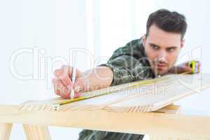 Worker marking on wooden plank
