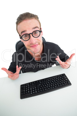 Confused businessman with glasses at desk