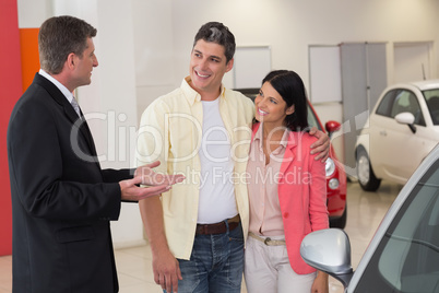 Smiling businessman speaking with his customers