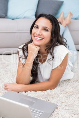 Happy brunette using her laptop