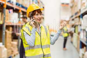 Warehouse manager talking on the phone looking around